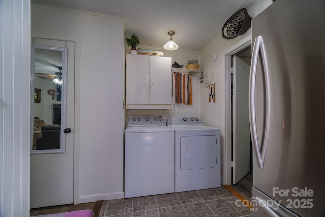 washroom with cabinet space, washer and clothes dryer, and a textured ceiling