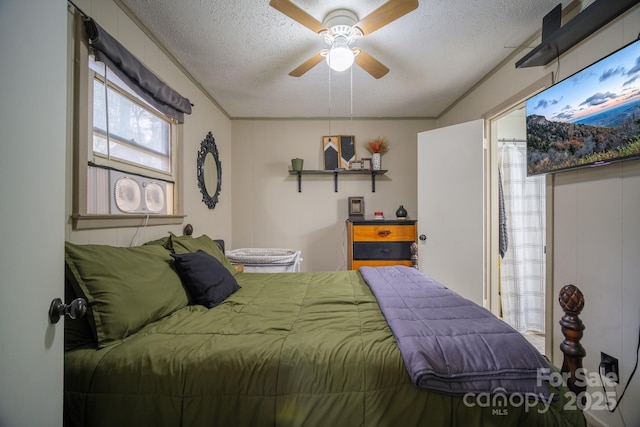 bedroom with a ceiling fan, a textured ceiling, and ornamental molding