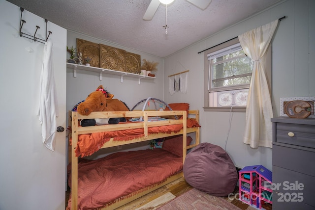 bedroom featuring a ceiling fan, a textured ceiling, and wood finished floors