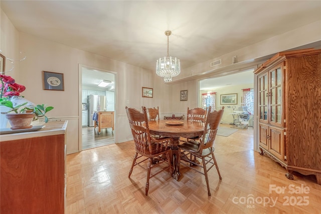 dining room with visible vents and a notable chandelier