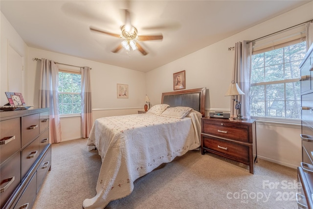 bedroom featuring light carpet, ceiling fan, and baseboards