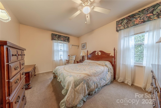 bedroom with baseboards, light colored carpet, a ceiling fan, and lofted ceiling