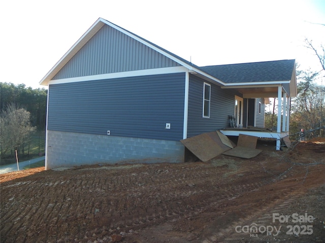 view of home's exterior with covered porch and roof with shingles