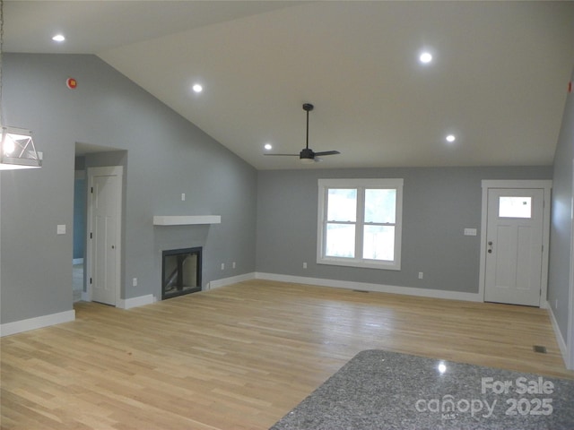 unfurnished living room featuring light wood-type flooring, a healthy amount of sunlight, and a fireplace