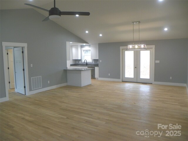 kitchen with french doors, visible vents, open floor plan, white cabinets, and a peninsula