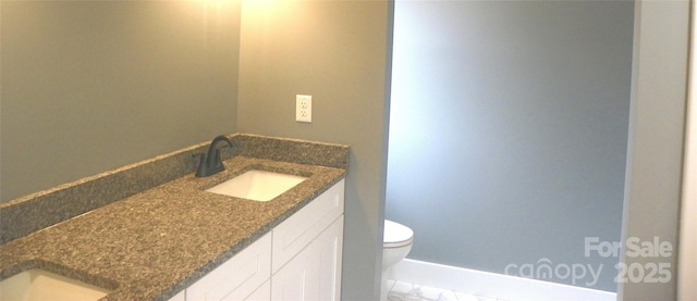 bathroom with marble finish floor, vanity, and toilet