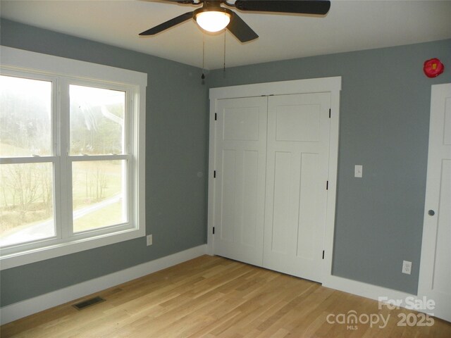 unfurnished bedroom with ceiling fan, visible vents, baseboards, a closet, and light wood finished floors