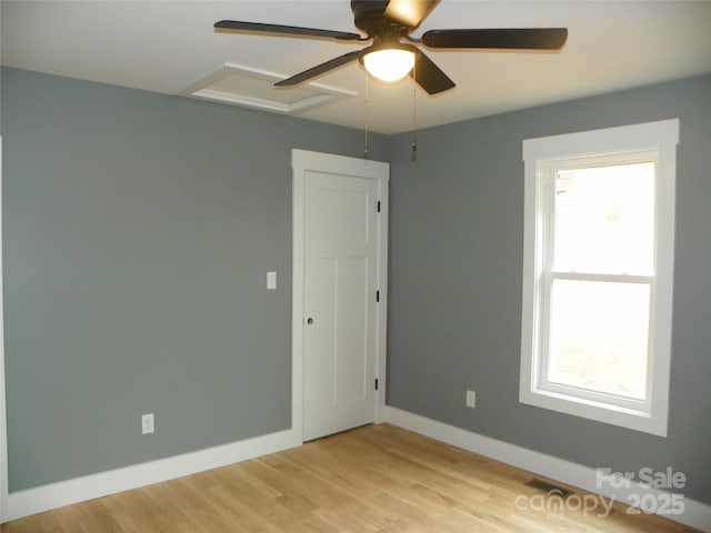 unfurnished room featuring ceiling fan, light wood-style flooring, and baseboards