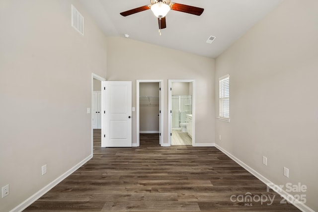 unfurnished bedroom with baseboards, visible vents, connected bathroom, dark wood-style floors, and a spacious closet