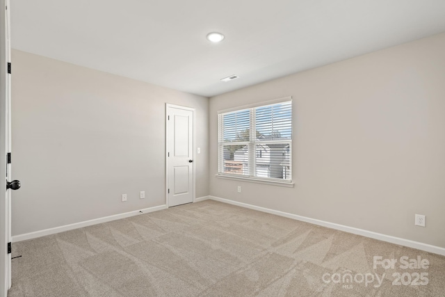 spare room featuring carpet and baseboards