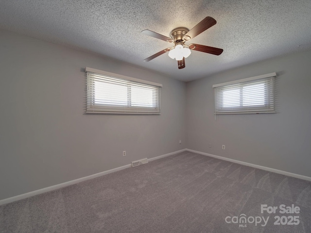 unfurnished room featuring visible vents, plenty of natural light, carpet, and baseboards