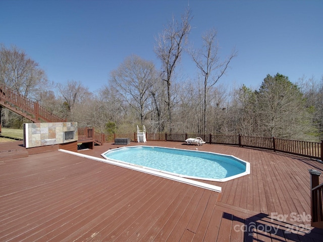 view of pool featuring a fenced in pool, fence, and a wooden deck