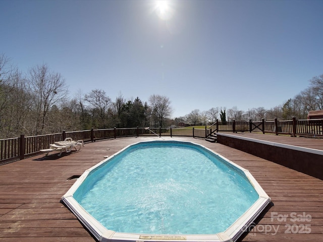 view of swimming pool featuring a fenced in pool and a wooden deck