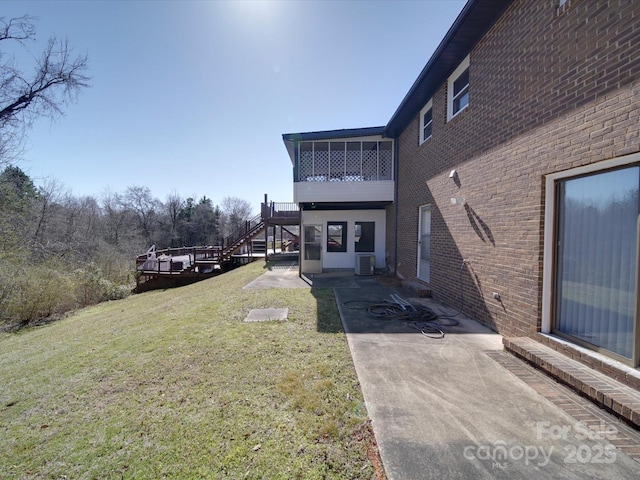 view of yard with a wooden deck, stairs, cooling unit, a sunroom, and a patio area