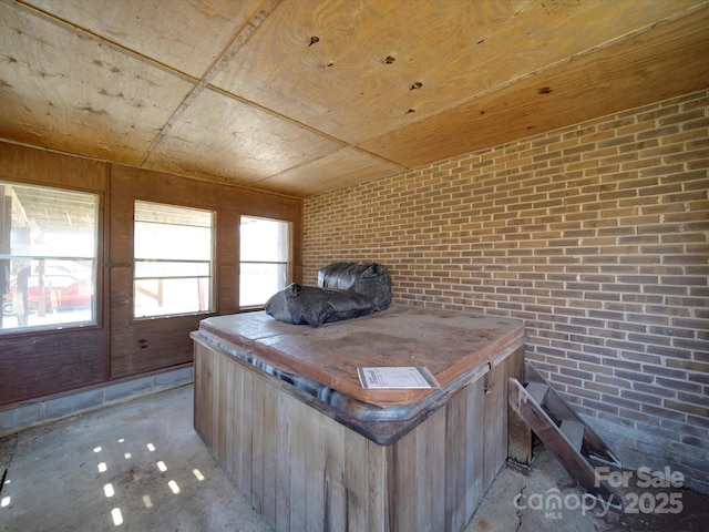 miscellaneous room featuring wood ceiling and brick wall