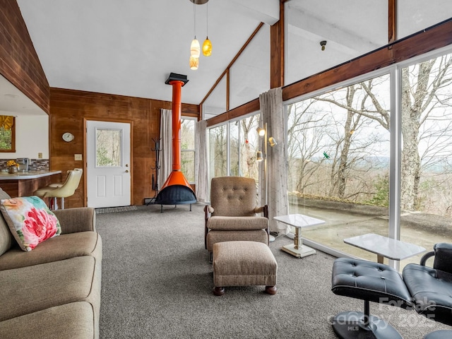 675 Foster Hill Dr, Hendersonville, NC 28739 - carpeted living room with plenty of natural light, wood walls, a wood stove, and vaulted ceiling