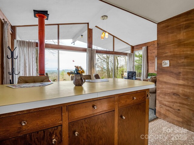 675 Foster Hill Dr, Hendersonville, NC 28739 - kitchen featuring brown cabinetry, lofted ceiling with beams, light countertops, wood walls, and open floor plan