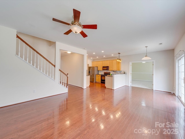 unfurnished living room featuring recessed lighting, light wood-style flooring, baseboards, and stairs