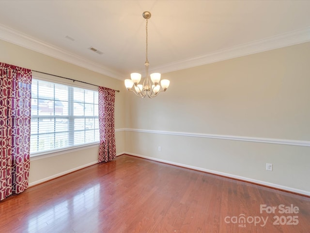 unfurnished room with a chandelier, ornamental molding, wood finished floors, and visible vents