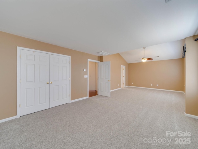 unfurnished bedroom featuring carpet, visible vents, vaulted ceiling, ceiling fan, and baseboards