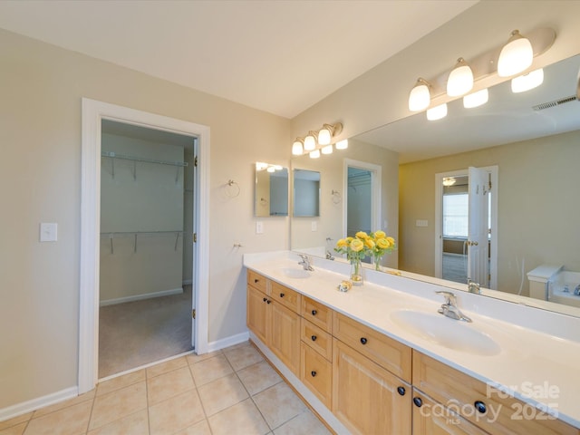 full bathroom featuring double vanity, tile patterned flooring, baseboards, and a sink