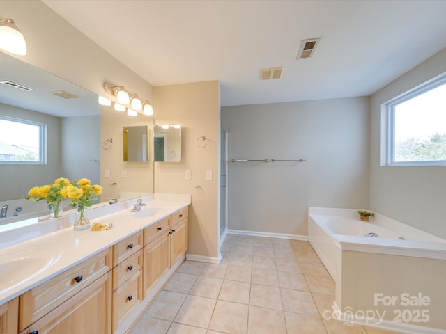 bathroom featuring a bath, tile patterned flooring, visible vents, and a sink