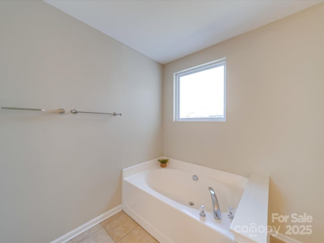 bathroom with a garden tub, baseboards, and tile patterned floors