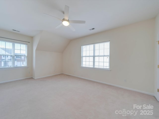 additional living space featuring carpet floors, a wealth of natural light, and visible vents