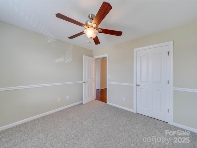 unfurnished bedroom featuring ceiling fan, carpet flooring, and baseboards