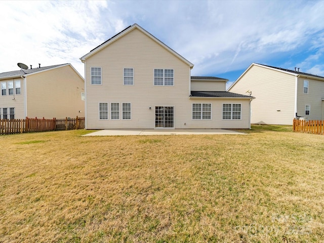 rear view of house featuring a patio, a lawn, and fence