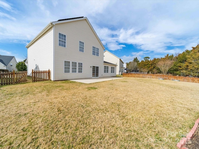 rear view of house featuring a patio area, a lawn, and fence