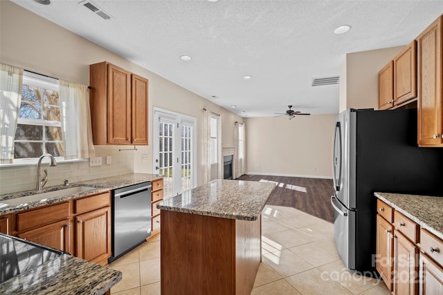 kitchen featuring light tile patterned floors, visible vents, stainless steel appliances, and a sink