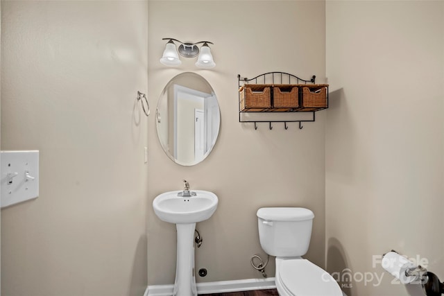 bathroom with toilet and baseboards