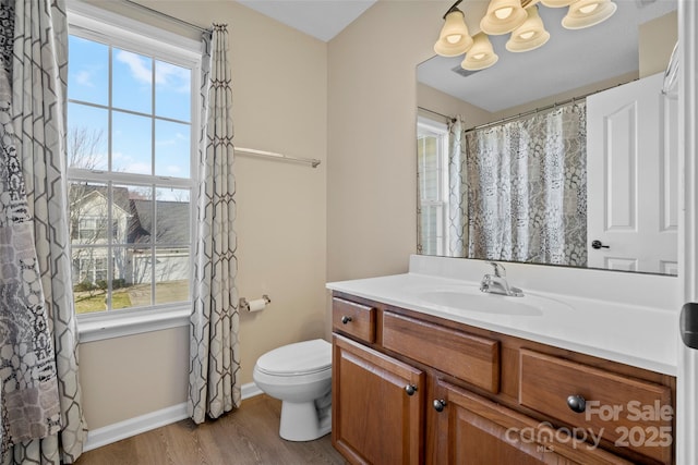 bathroom featuring vanity, plenty of natural light, wood finished floors, and toilet