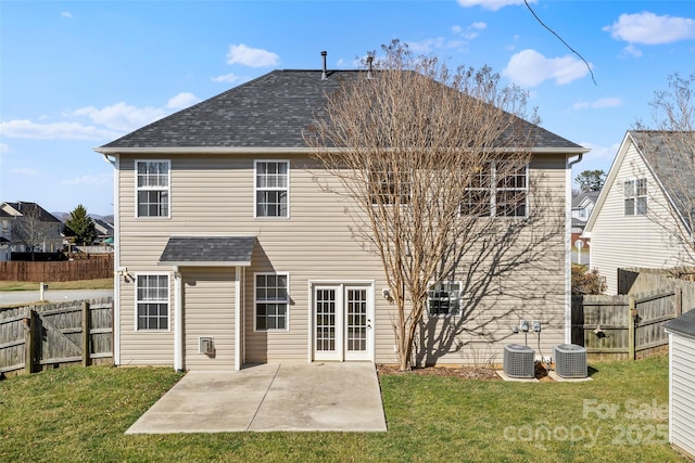 back of house featuring a fenced backyard, cooling unit, a shingled roof, a yard, and a patio area