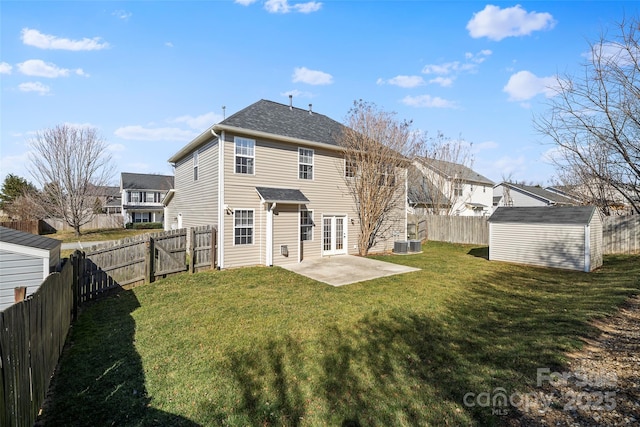 back of house featuring a yard, a patio, a shed, a fenced backyard, and an outdoor structure