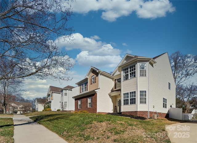 view of property exterior with central air condition unit, a residential view, fence, and a yard