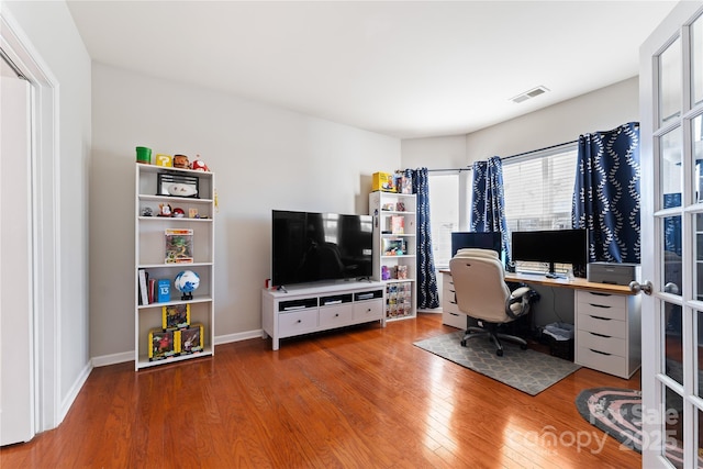 office with french doors, visible vents, baseboards, and hardwood / wood-style flooring