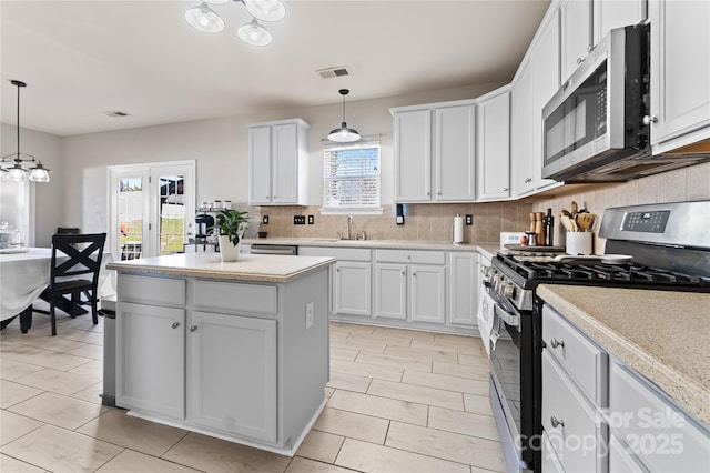 kitchen featuring a center island, visible vents, decorative backsplash, appliances with stainless steel finishes, and a sink