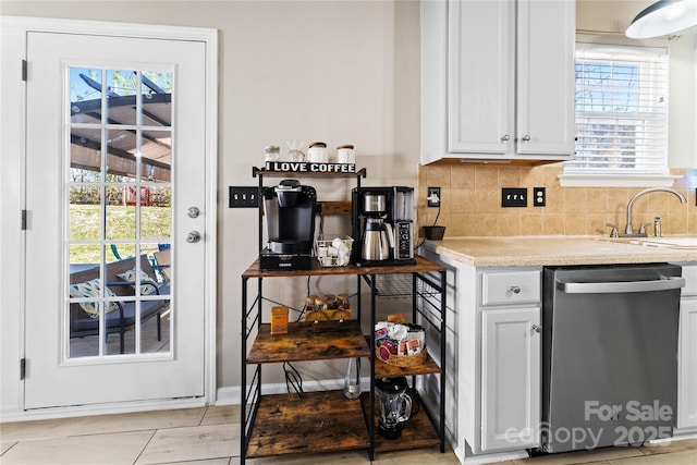 kitchen featuring a sink, tasteful backsplash, white cabinetry, and stainless steel dishwasher