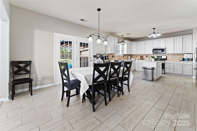 dining room featuring baseboards, visible vents, and light wood-style flooring