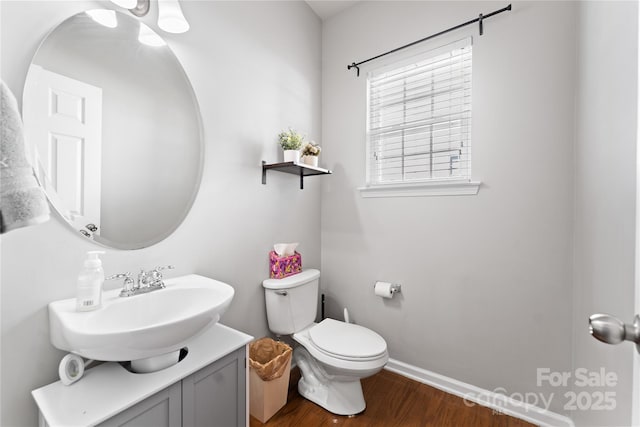 bathroom featuring vanity, wood finished floors, toilet, and baseboards