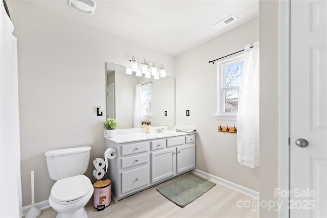 bathroom featuring toilet, baseboards, visible vents, and vanity