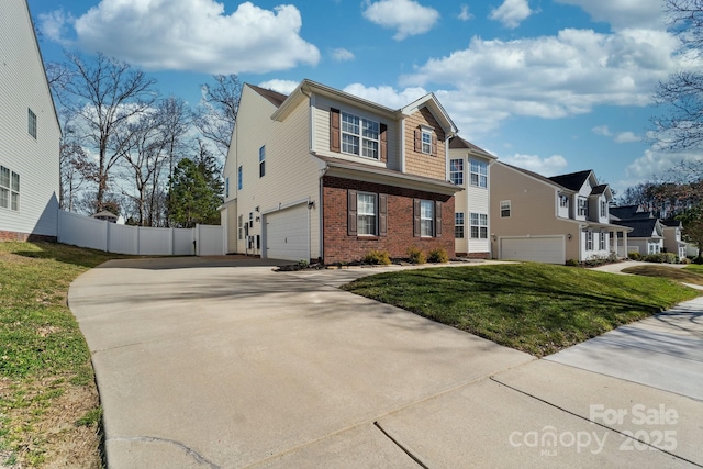 traditional-style home with a front yard, brick siding, fence, and an attached garage