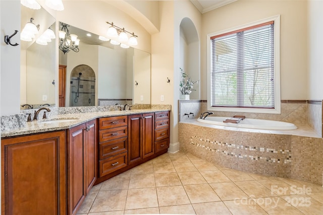 full bath with a sink, a bath, tile patterned floors, double vanity, and walk in shower