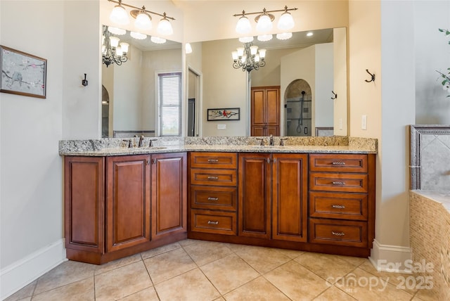 bathroom featuring double vanity, tile patterned flooring, a chandelier, and a sink