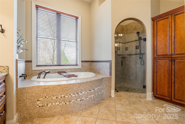 bathroom featuring tile patterned floors, a garden tub, visible vents, and a shower stall