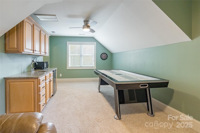 recreation room with lofted ceiling, ceiling fan, light colored carpet, a sink, and baseboards