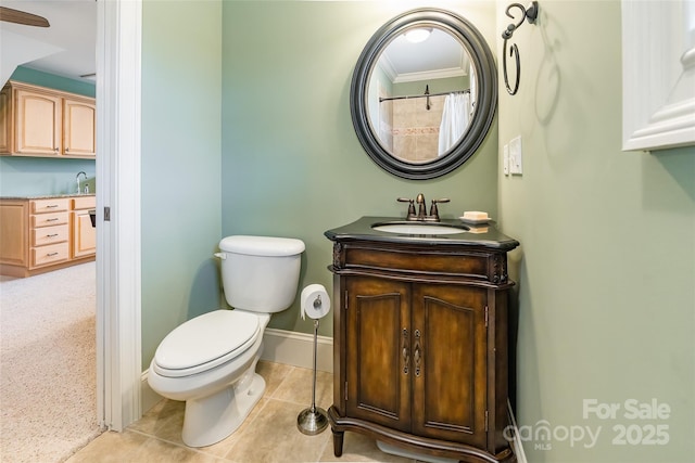 bathroom featuring toilet, vanity, baseboards, tile patterned floors, and crown molding