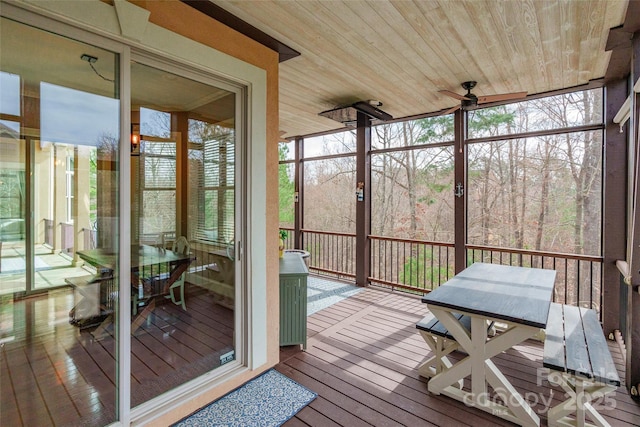 sunroom featuring wood ceiling, a ceiling fan, and a wealth of natural light